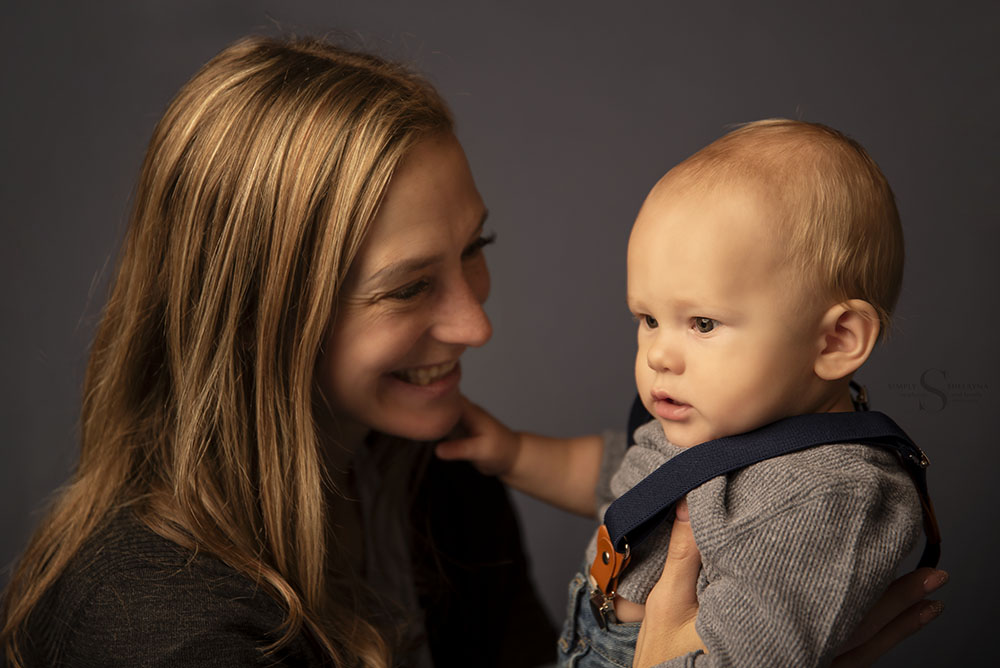 A baby boy sits for a portrait with his mother with Simply Shelayna Family Photography in CNY.