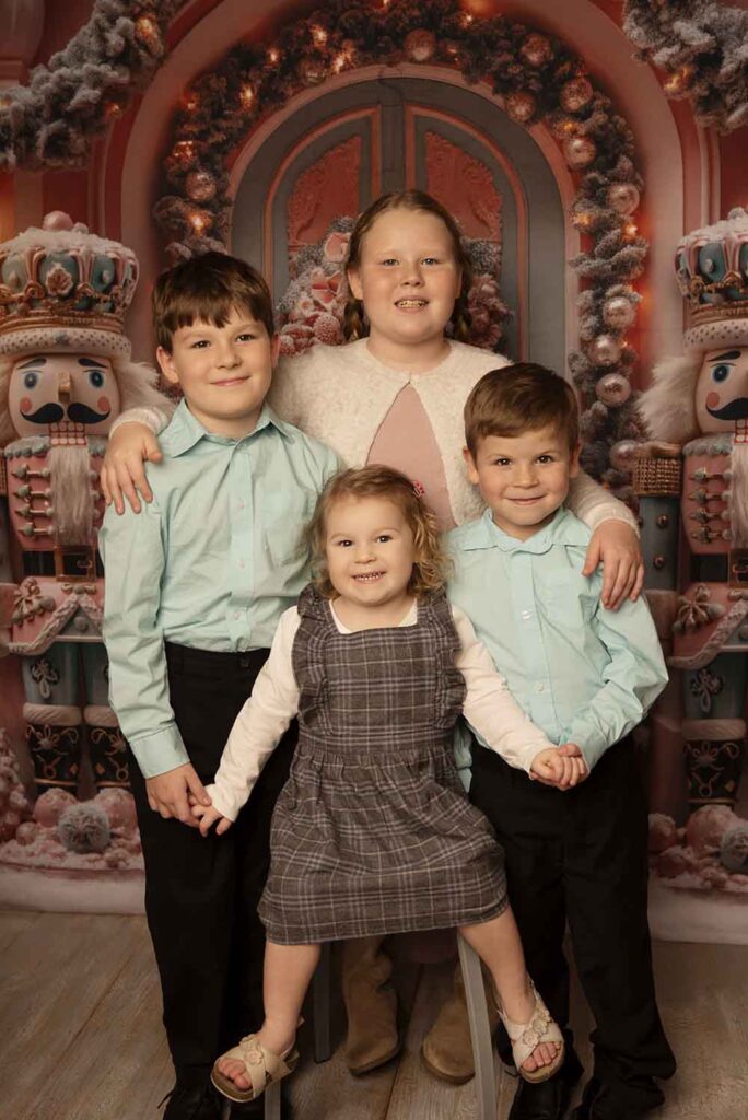 Four siblings pose for a Christmas portrait with Simply Shelayna Family Photography in Syracuse NY.