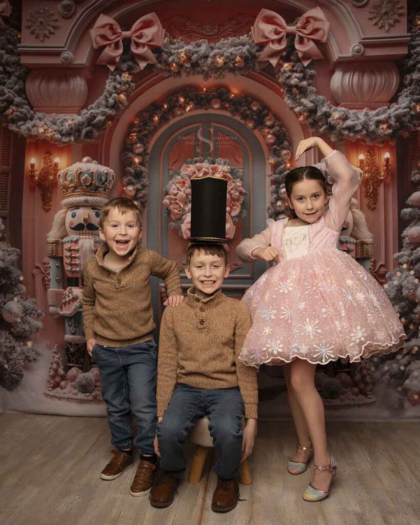 Three siblings pose together for a nutcracker Christmas portrait with Simply Shelayna Family Photographer in Syracuse NY.