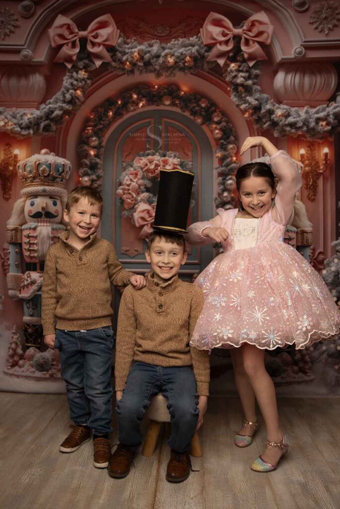 Three siblings pose together for a nutcracker Christmas portrait with Simply Shelayna Family Photographer in Syracuse NY.