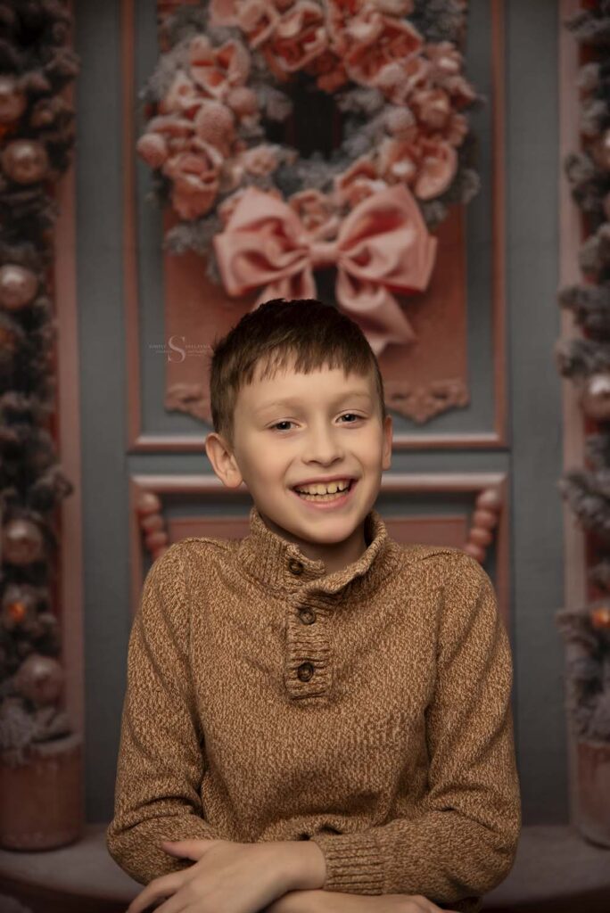 A young boy smiles pleasantly for a portrait with Simply Shelayna Family Photography in Syracuse NY.