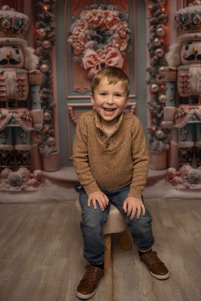 A young boy smiles pleasantly for a portrait with Simply Shelayna Family Photography in Syracuse NY.