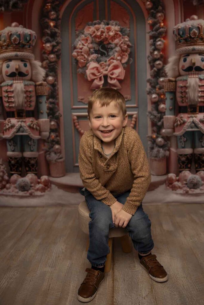 A young boy smiles pleasantly for a portrait with Simply Shelayna Family Photography in Syracuse NY.