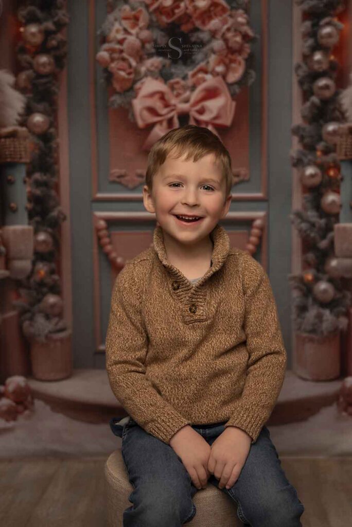 A young boy smiles pleasantly for a portrait with Simply Shelayna Family Photography in Syracuse NY.