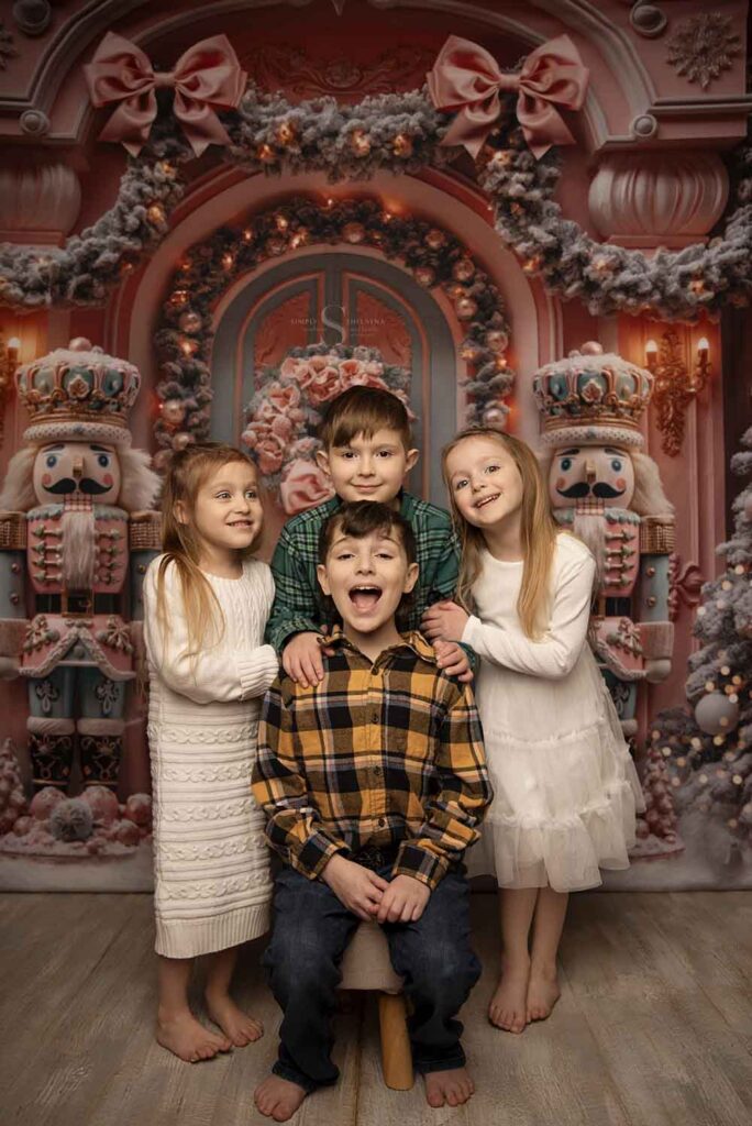 Four siblings, two boys and two girls pose for a portrait with Simply Shelayna Family Photographer in her Limited Edition Christmas portraits in Oswego NY.