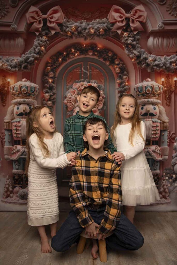 Four siblings, two boys and two girls pose for a portrait with Simply Shelayna Family Photographer in her Limited Edition Christmas portraits in Oswego NY.
