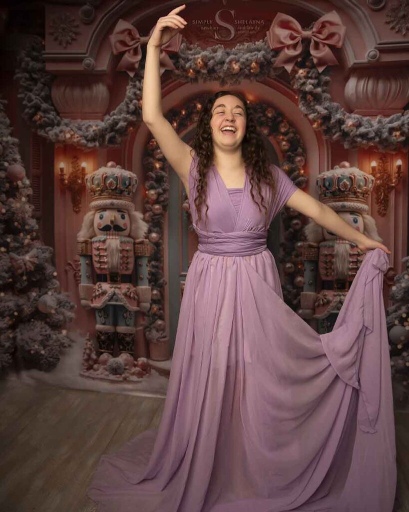 A teenage girl, dressed in a dew trendy purple infinity dress, poses for a birthday portrait with Simply Shelayna Family Photography in CNY.