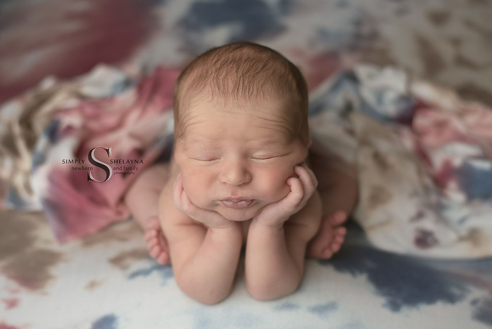 A baby boy is posed in froggy for his newborn portraits with Simply Shelayna baby photography in Oswego NY.