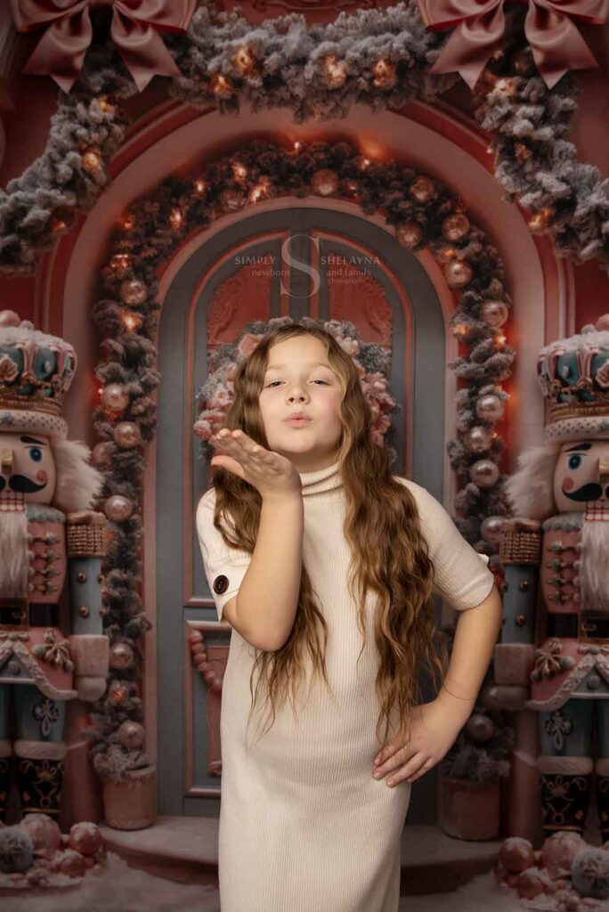 A young girl blows kisses at the camera for a portrait with Simply Shelayna Family Photography in CNY.