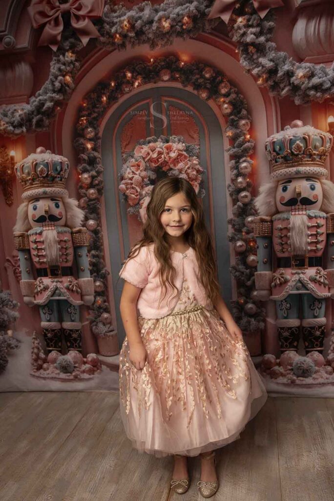 A young girl wears a pink gown for a Christmas portrait with Simply Shelayna Family Photography in Oswego NY.