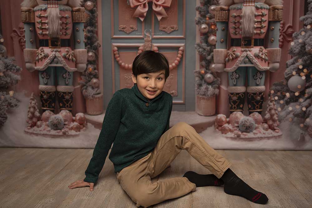 a young boy poses on the floor with his back knee elevated for a Christmas portrait with Simply Shelayna Family Photography in Oswego NY.