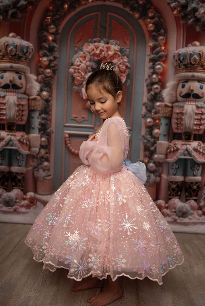 A little girl looks over her shoulder for a Christmas portrait with Simply Shelayna Family Photography in CNY.