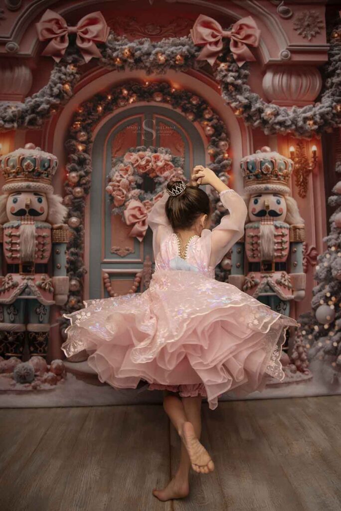 A young girl dances and twirls in a pink nutcracker ballgown with Simply Shelayna Family Photography in Oswego County NY.