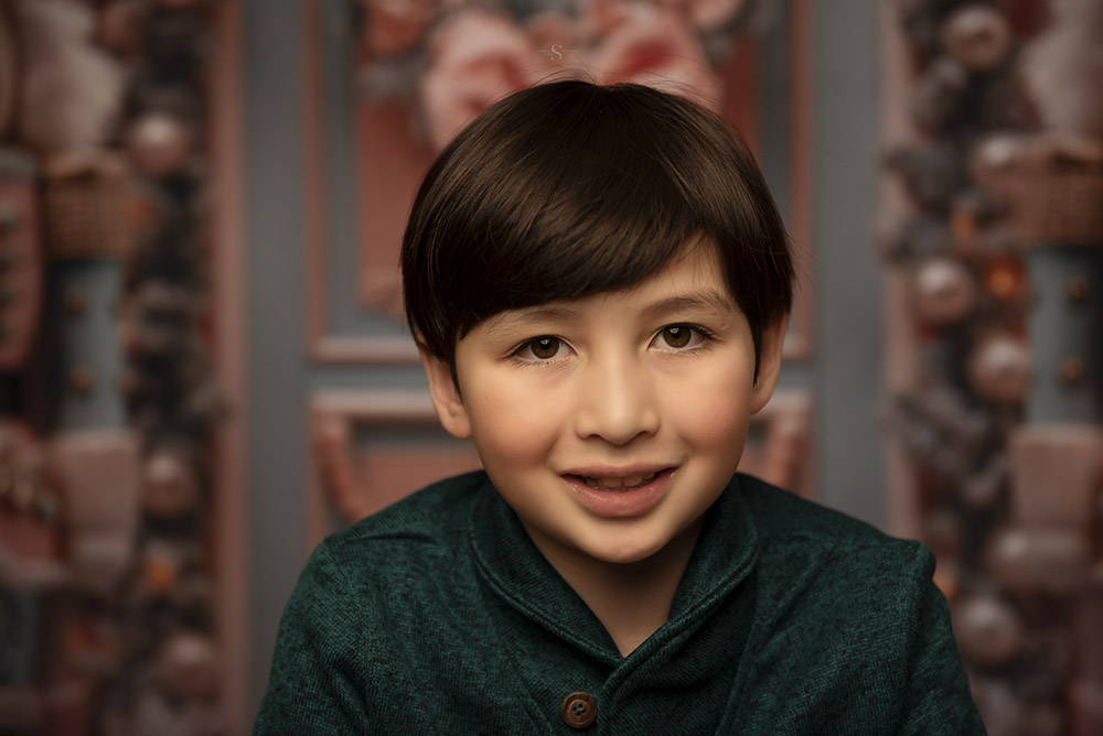 A young boy leans into the camera for a Christmas portrait with Simply Shelayna Photography in Oswego NY.