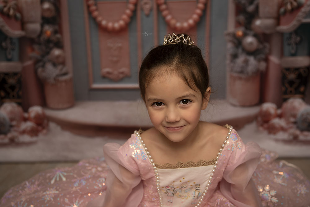 A toddler girl smiles for a Christmas portrait with Simply Shelayna Family Photographer in CNY.