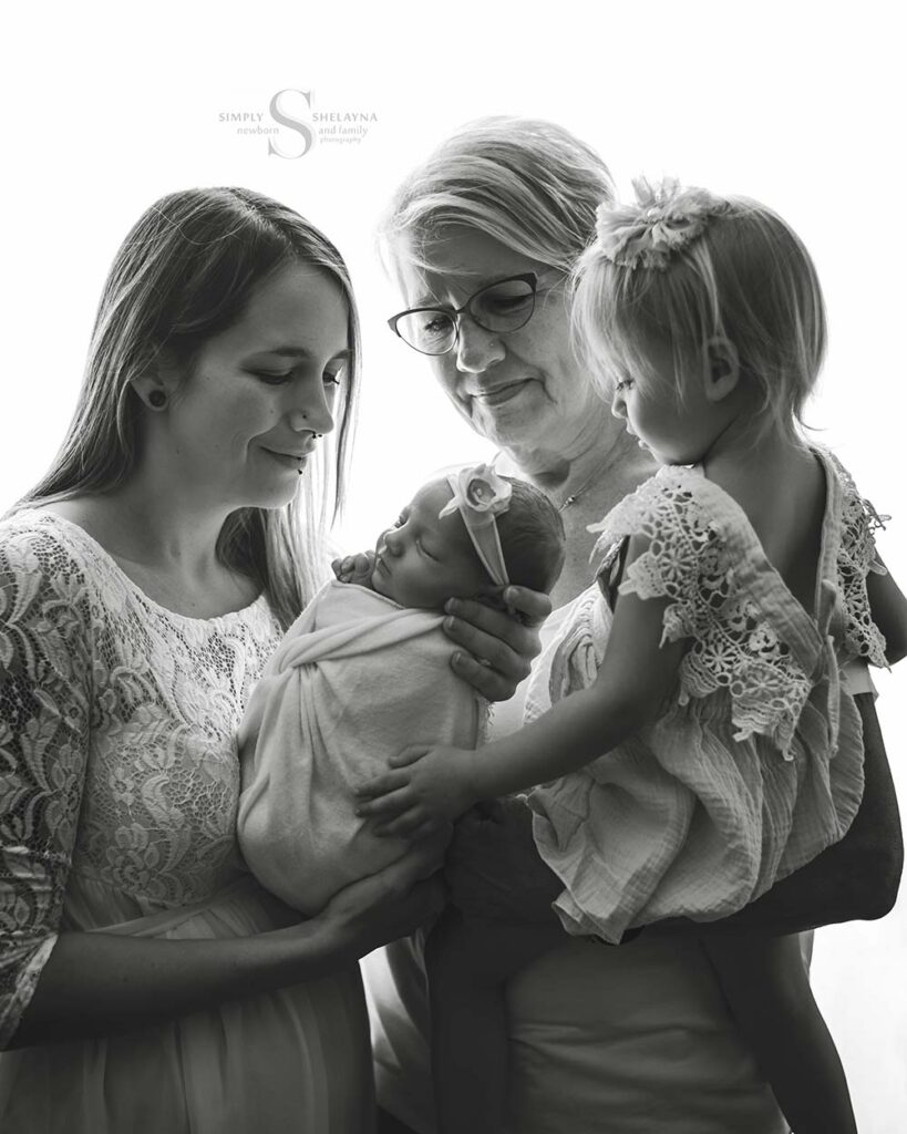 A generational portrait that includes grandma, mother and 2 daughters portrayed in black and white with Simply Shelayna Family Photography in Oswego NY.