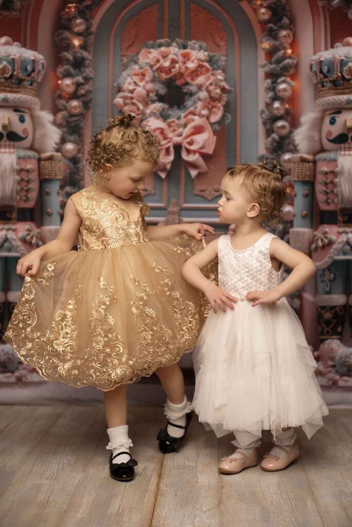 Two sisters pose in Christmas dressed for a portrait with Simply Shelayna Christmas Photography in Albany NY.