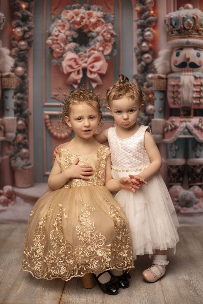 Two sisters pose in Christmas dressed for a portrait with Simply Shelayna Christmas Photography in Albany NY.