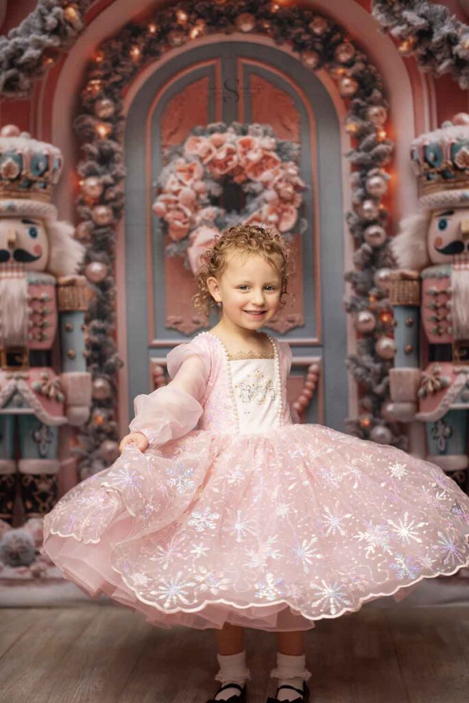 A young girl swirls her dress to capture the full effect of a twirl in a Christmas portrait with Simply Shelayna Photography in Albany NY.
