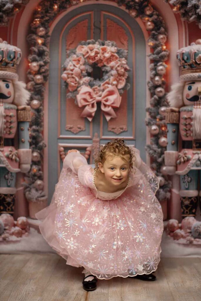 A young girl curtesy in a pink Nutcracker Christmas dress for a portrait with Simply Shelayna Photography in Albany NY.