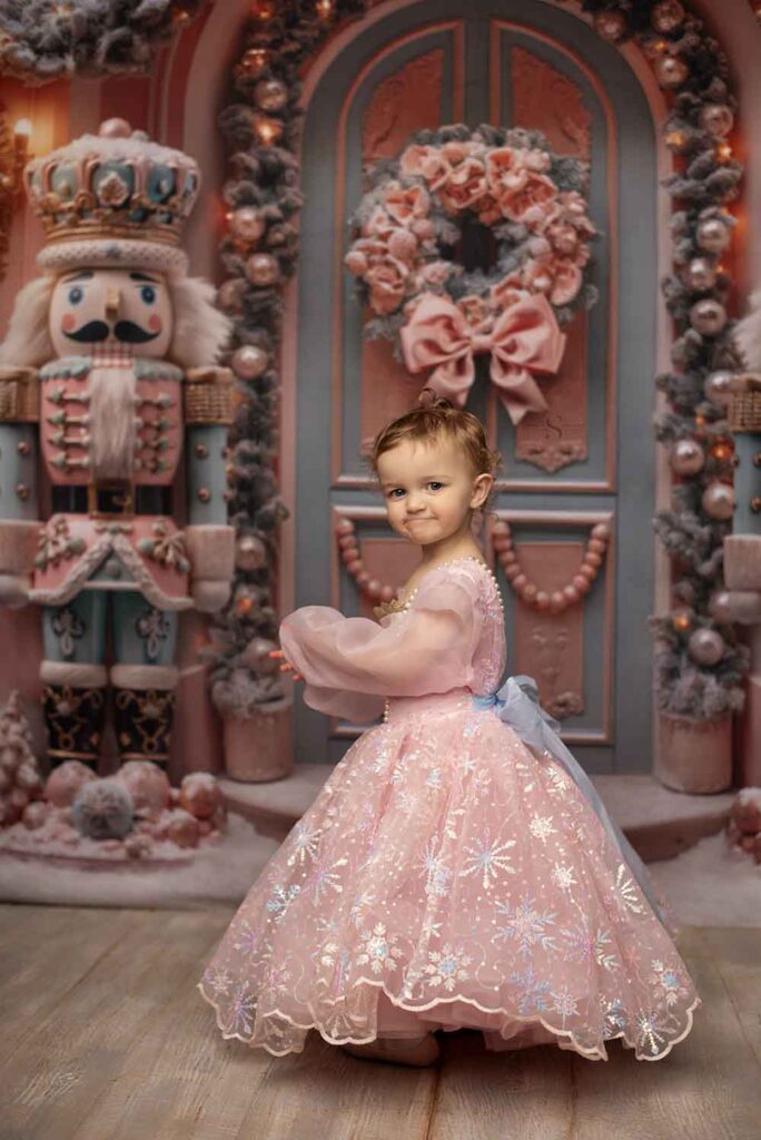 A young girl poses in a pink Nutcracker Christmas dress for a portrait with Simply Shelayna Photography in Albany NY.