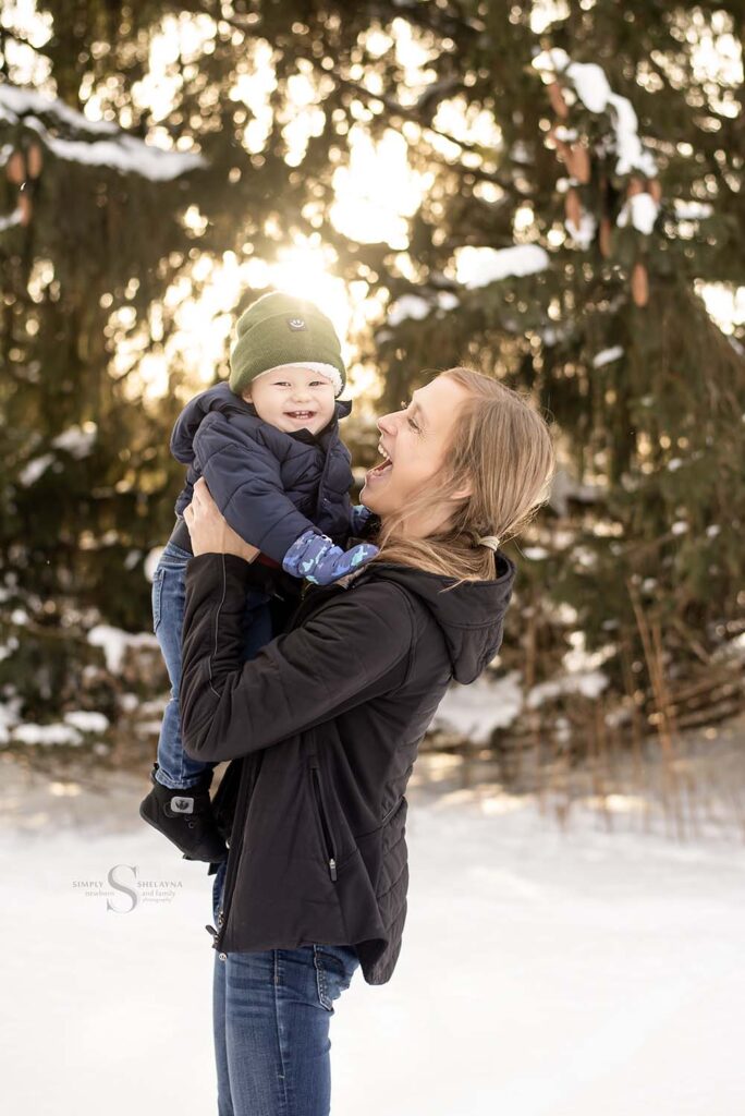 A mother holds close her one year old sun in a glowing snow theme with Simply Shelayna Family Photographer in Oswego NY.