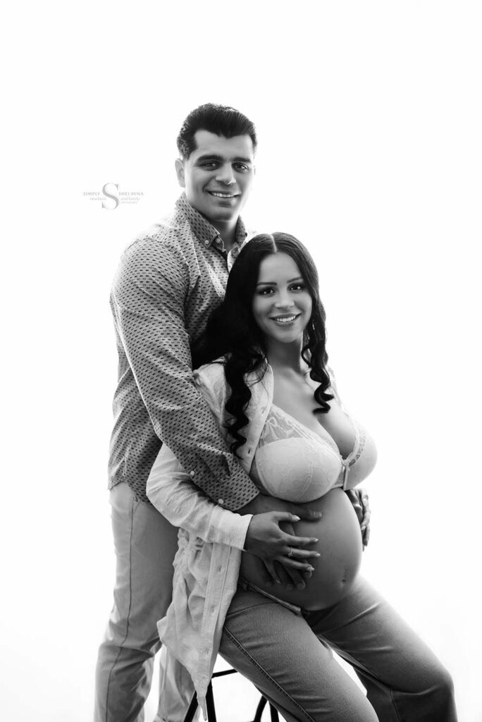 A couple hold each other close for a maternity portrait with Simply Shelayna Maternity Photography in Oswego NY.