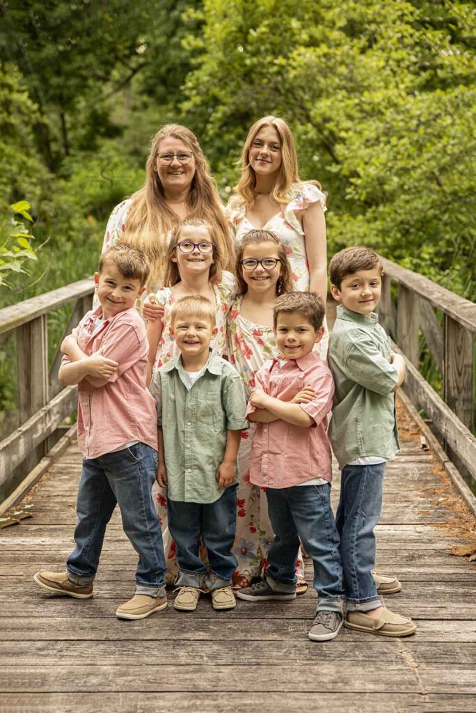 A mother and her 7 children pose for an outdoor portrait with Simply Shelayna Family Photography in Oswego NY.