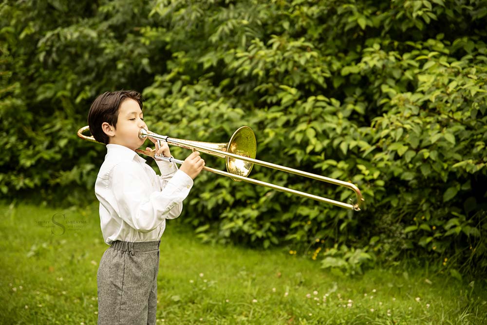 A young boy plays his trombone with Simply Shelayna Child Photography in CNY.