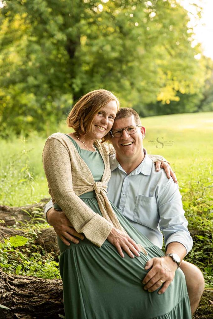 A husband and wife sit together for a portrait with Simply Shelayna Family Photography in CNY.