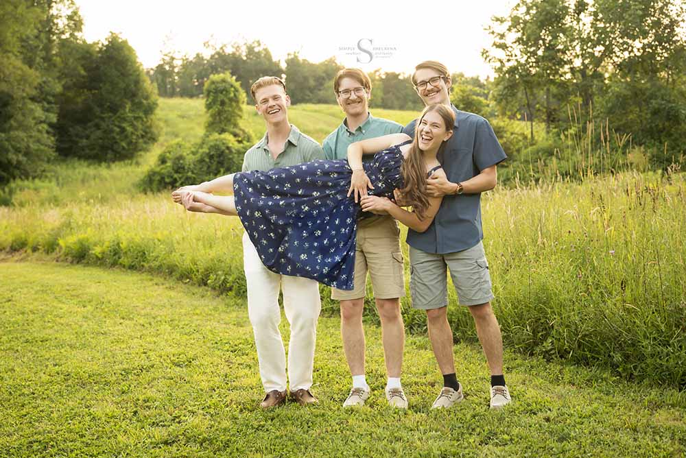 3 brothers recreate a portrait while holding their younger sister at Fall Brook NY with Simply Shelayna Photography in Oswego NY.