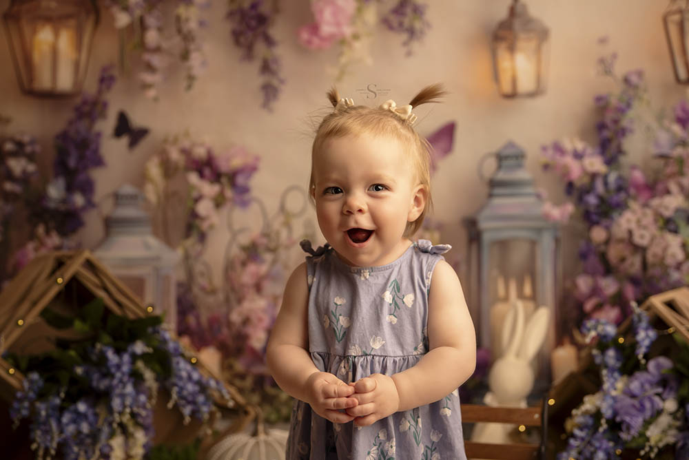 A baby girl looks on in awe as she is photographed for her first birthday with Simply Shelayna Family Photography in CNY.