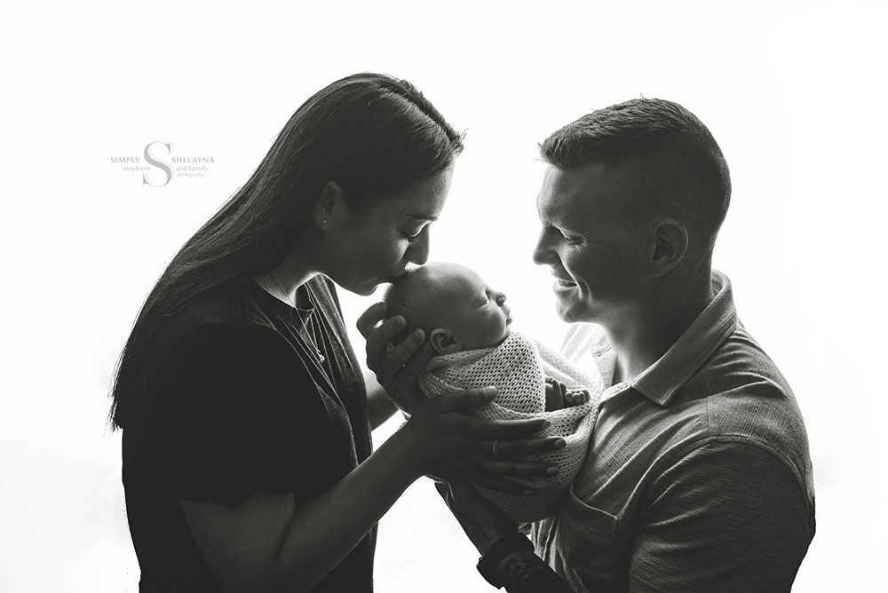 A black and white portrait of a family of 3 with their newborn son with Simply Shelayna Newborn Photography in Syracuse NY.