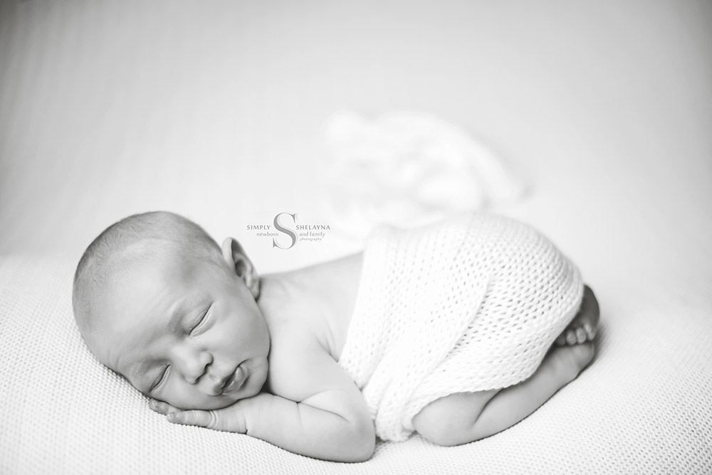 A black and white portrait of a newborn in bum up pose with Simply Shelayna newborn photography in Cicero NY.