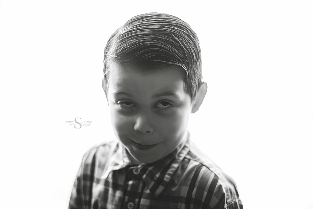 A young boy makes a really silly face for his 5 year old portrait session with Simply Shelayna child photography in CNY.